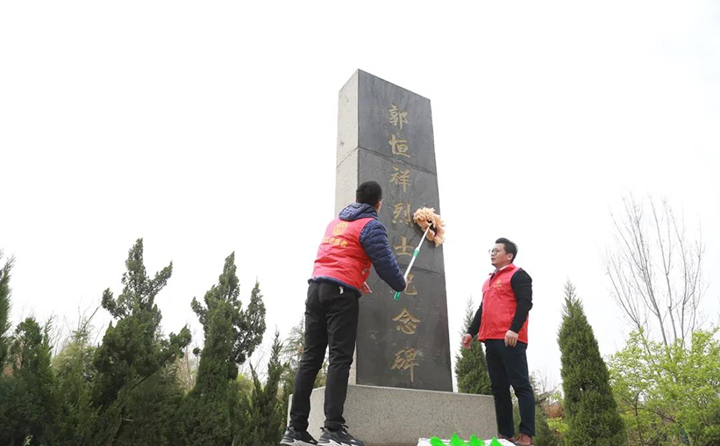 職工志愿者對(duì)紀(jì)念碑進(jìn)行清理、擦拭.jpg